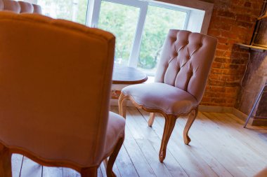 Bir sandalyenin güzel sandalyeleri pencerenin yanında duruyor, tavan arası atmosferinde..