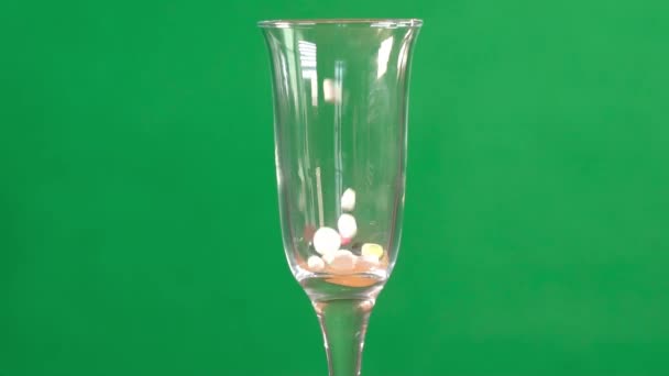 Covid Flerfärgade Tabletter Häller Ett Rent Champagneglas Grön Kromnyckel Bakgrund — Stockvideo