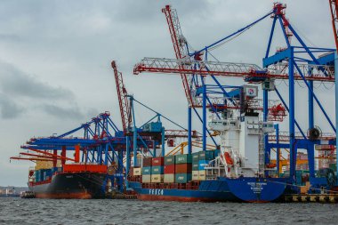 2015 Yazı - Vladivostok, Rusya - Vladivostok Endüstriyel Deniz Cephesi. Kargo vinçleri büyük bir deniz şehrinin ticaret limanında. Ticari kargo gemileri arka planda uzun vinçlerin önünde duruyor..