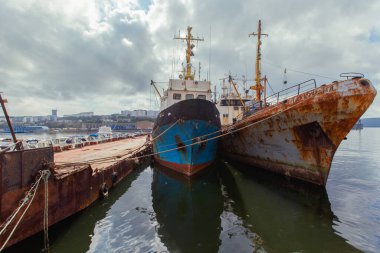 2015 yazı - Vladivostok, Rusya - Golden Horn Körfezi 'ndeki iskeledeki eski paslı gemiler. Fabrikada tamir bekleyen eski gemiler..