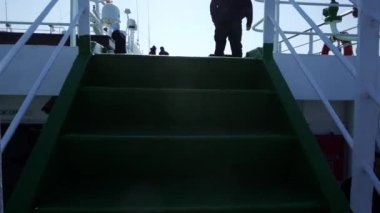 2019 Baharı - Vladivostok, Rusya - Doğu Rüya Yolcu Feribotu. Güneşli bir günde açık denizde bir yolcu feribotunun üst güvertesinde gezinen yolcular.