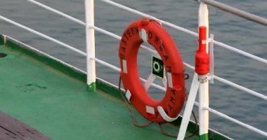 2019 baharında Donghae, Güney Kore yolcu gemisinin açık güvertesinde kırmızı can simidi. Yaşam şamandırası denizin arka planında asılı..