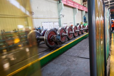 Demiryolu vagonlarının tekerlekleri olan akslar tamir tesisinde bir sırada yatıyor.