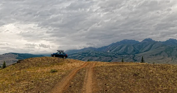 Car  mountains and storm cloud — Stock Photo, Image