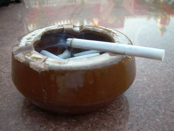 Sigara Sigara izmariti kül tablası mermer tablo içinde — Stok fotoğraf