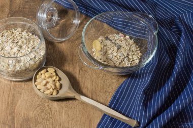 Müsli, granola, tahıl ve ahşap bir masa üzerinde bir cam kap içinde fındık. Rustik gıda.