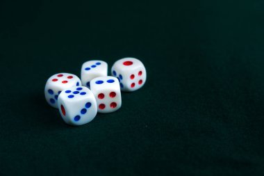 Beyaz zar bir masanın üzerine atılmış. Koyu yeşil kumaş.