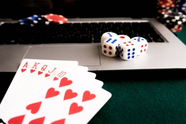 Defter, kartlar, zar ve yeşil çuha üzerindeki fişlere. Online casino her zaman var.