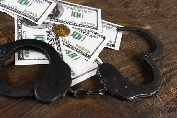 Manette su un mucchio di banconote americane. Il significato simbolico dei crimini economici . — Foto Stock