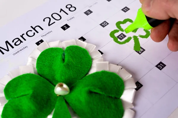 El calendario es una hoja de trébol y el hombre con el marcador celebra el día de San Patricio. Copiar pasta —  Fotos de Stock