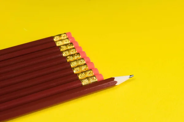 Της επιχειρηματικής ιδέας - πολύ ίδιο μολύβια και ένα διαφορετικό μολύβι σε φόντο κίτρινο χαρτί. Είναι το σύμβολο της ηγεσίας, ομαδική εργασία. — Φωτογραφία Αρχείου