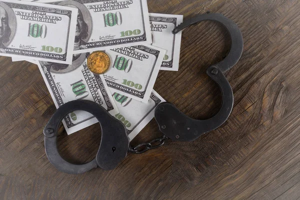 Menottes sur un tas de billets américains. La signification symbolique des crimes économiques . — Photo
