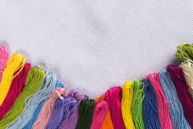 Beyaz tuval üzerine nakış için renkli iplik. Kopya spase.