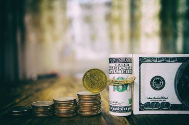 Yüz dolarlık banknotlar üç aylık dönemler ve bir dolar sikke yığını.