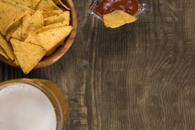 Bir ahşap masa bir fincan filtre uygulanmamış bira, cips ve salsa. Kopyala Yapıştır