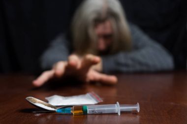 Bağımlısı masada dozu şırınga elini çeker