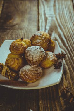 Lezzetli eklerleri şeker, krema ile serpilir üzerinde ahşap bir masa standı. Kopya spase.