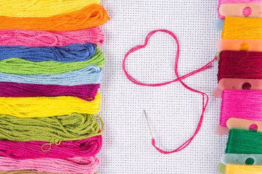 Bir kalp şeklinde kırmızı iplik ile renkli iplik nakış beyaz tuval üzerine, iğne için. Bir hobi için aşk kavramı. Kopya spase