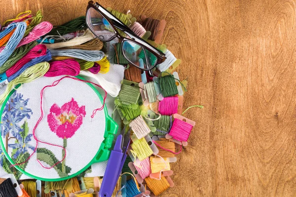 Kanaviçe işi işlemidir. Tuval üzerinde çemberler, iğneler, nakış ipi ve desen.
