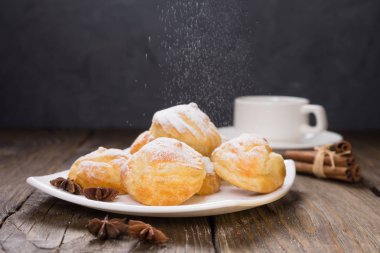 Lezzetli eklerleri şeker, krema ile serpilir üzerinde ahşap bir masa standı. Kopya spase.