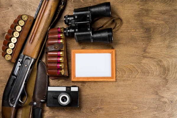 Vadászfegyverek, lőszerek, kamera és frame a fotó a trófeát és a fából készült háttér. Mintája fel. — Stock Fotó