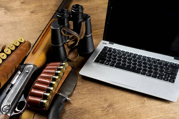 Le fusil de chasse et les munitions sont prêts. L'ordinateur portable est un endroit pour vos inscriptions. Espace de copie. Maquette . — Photo