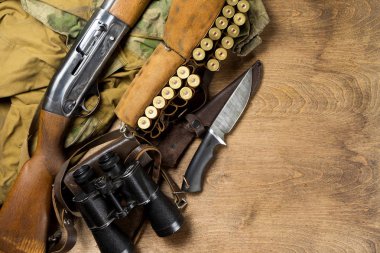 Av tüfeği ve mühimmat ahşap arka plan üzerinde yalan. Kopya alanı