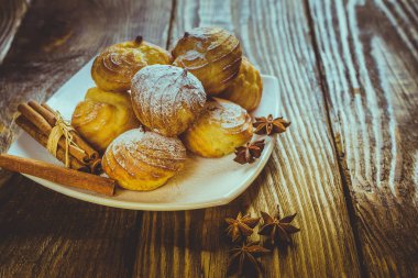 Lezzetli eklerleri şeker, krema ile serpilir üzerinde ahşap bir masa standı. Kopya spase.