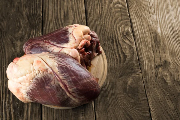 Coração de carne em uma mesa rústica de madeira. Espase de cópia — Fotografia de Stock