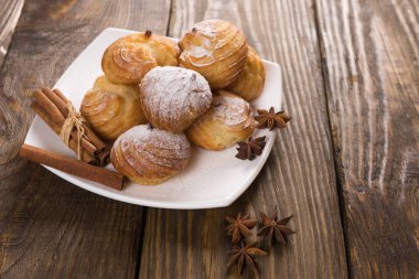 Lezzetli eklerleri şeker, krema ile serpilir üzerinde ahşap bir masa standı.