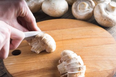 Kadın kesme champignon daire ahşap tahta üzerinde.