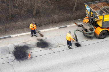 Yol işçilerinin havadan görünümü asfalt kaplama yıkıntı. Takım çalışması konsepti.