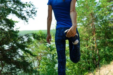 Koşudan önce ormanda uzanan orta yaşlı bir kadın.