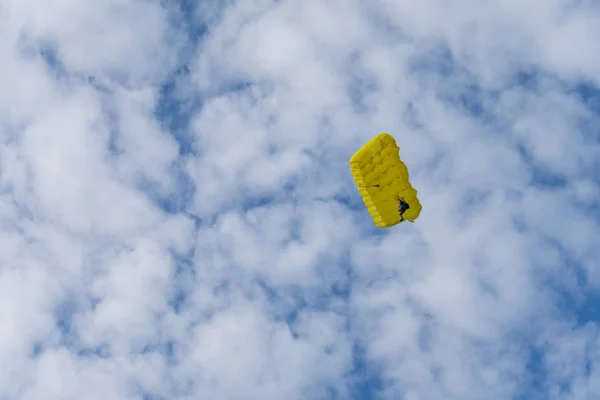 Fallschirmspringer stürzt mit Fallschirm gegen blauen Himmel. Fallschirmspringer am Himmel. Menschen unter Fallschirm am Himmel. — Stockfoto