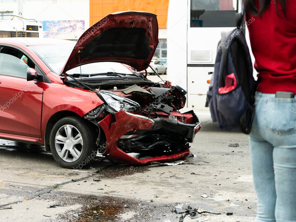Pedestrians stand and look at the consequences of a car accident.