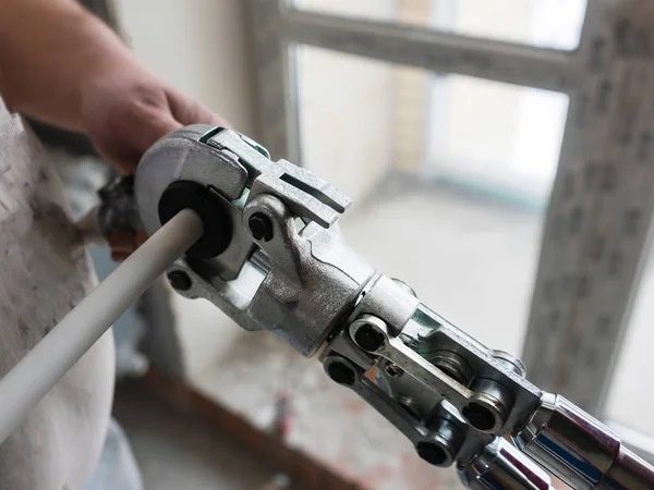 I lavoratori collegano i tubi con un rubinetto nell'appartamento. Utilizzare idraulico strumento di pressatura . — Foto Stock