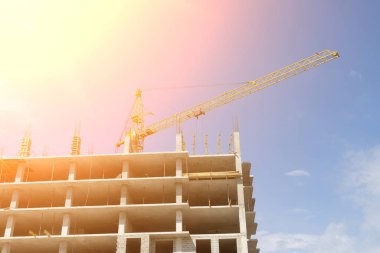 Mavi gökyüzüne karşı kule vinci olan inşaat alanı.