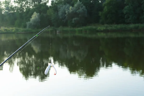 Karpfenangeln auf dem schönen blauen See mit Karpfenruten und Rutenschoten am Sommermorgen. Angeln von der Holzplattform. — Stockfoto