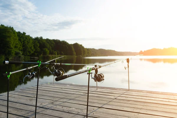 Ponty halászat gyönyörű kék tó ponty rudak és rúd hüvelyek a nyári reggel. Halászat a fa peronról. — Stock Fotó