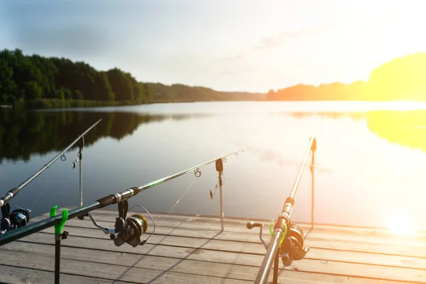 Ponty halászat gyönyörű kék tó ponty rudak és rúd hüvelyek a nyári reggel. Halászat a fa peronról. — Stock Fotó