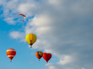 Mavi gökyüzünde uçan renkli sıcak hava balonları. Çok az renkli, sıcak hava balonu Balon Festivali 'ne iniyor..