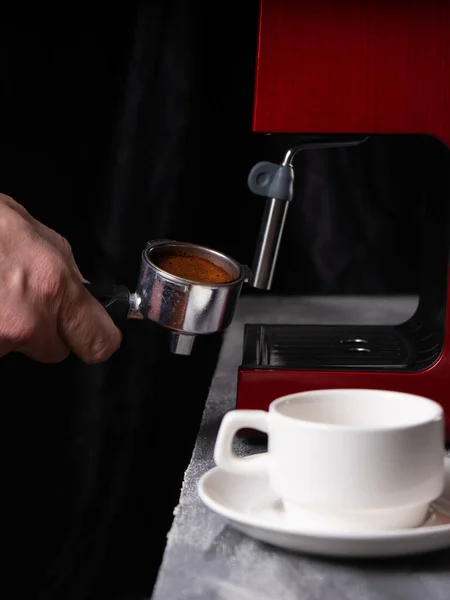 Un hombre con un portafilter en sus manos. El concepto de hacer café en una máquina de café. Foto en voz baja. vertical — Foto de Stock