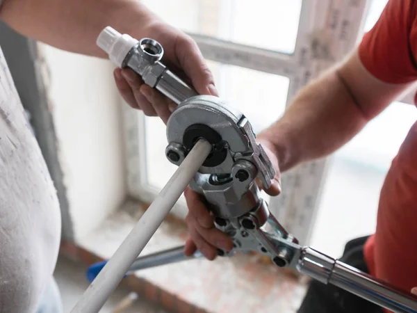 Workers connecting pipes with a tap in the apartment. Use plumbing pressing tool. — Stock Photo, Image