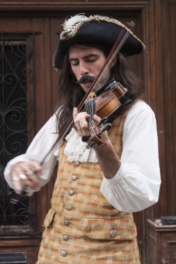 Bir keman çalmaya tarihsel giysili adam