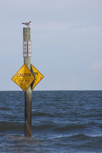 Praia sinal consultivo na água — Fotografia de Stock
