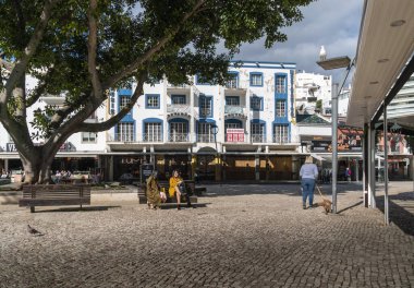 İnsanlar Albufeira 'daki Algarve, Portekiz' deki ana meydanda güneşin tadını çıkarıyorlar.
