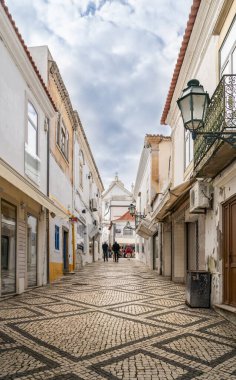 Albufeira, Algarve, Portekiz 'de dar bir sokakta desenli kaldırım taşları.
