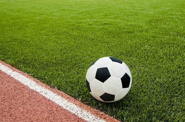 The football is near line on the artificial grass soccer field in the stadium