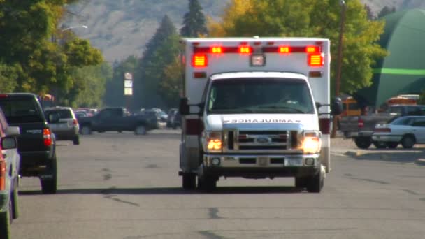 Ambulance met verlichting rijden in straat — Stockvideo