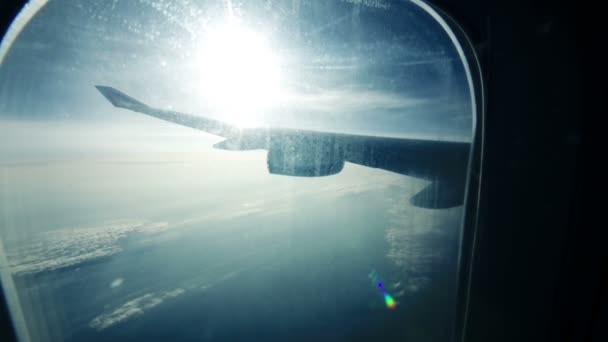 太陽フレアと雲の下に飛行機の翼を空気によって旅行中の照明からの眺め — ストック動画